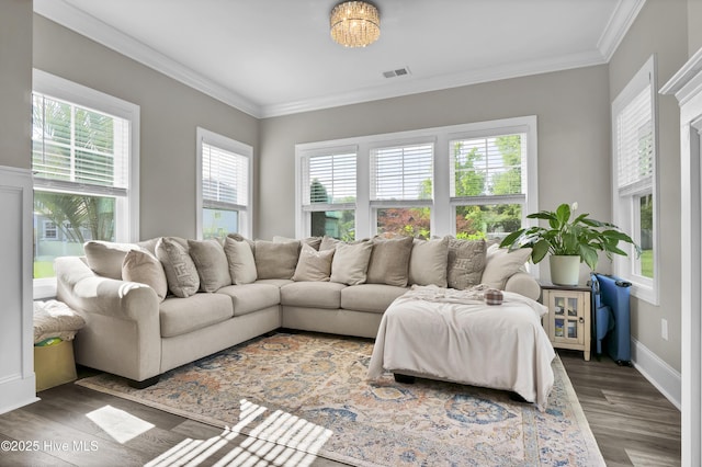 living room featuring healthy amount of natural light, wood finished floors, crown molding, and baseboards