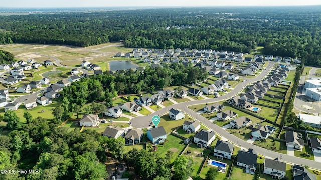 view of property location featuring a forest, nearby suburban area, and a large body of water