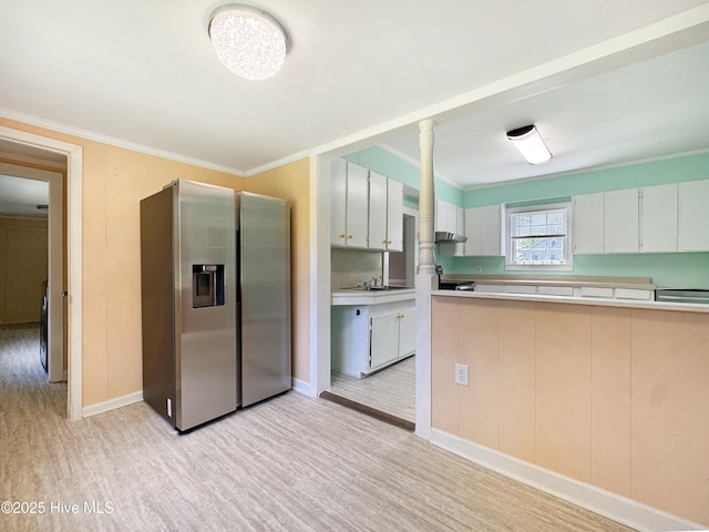402 Warren St, Williamston, NC 27892 - kitchen featuring stainless steel fridge with ice dispenser, light countertops, crown molding, baseboards, and light wood-style flooring