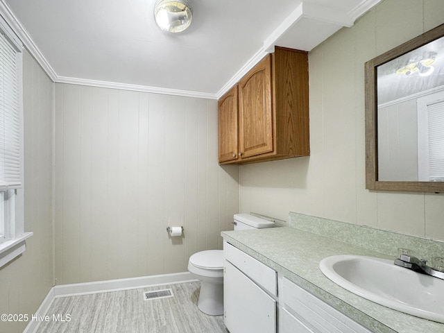 402 Warren St, Williamston, NC 27892 - bathroom featuring baseboards, wood finished floors, toilet, vanity, and crown molding