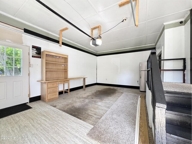 402 Warren St, Williamston, NC 27892 - garage with baseboards, a garage door opener, and freestanding refrigerator