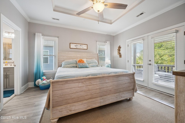 152 NW 1st St, Oak Island, NC 28465 - bedroom featuring a raised ceiling, light wood finished floors, multiple windows, and ornamental molding