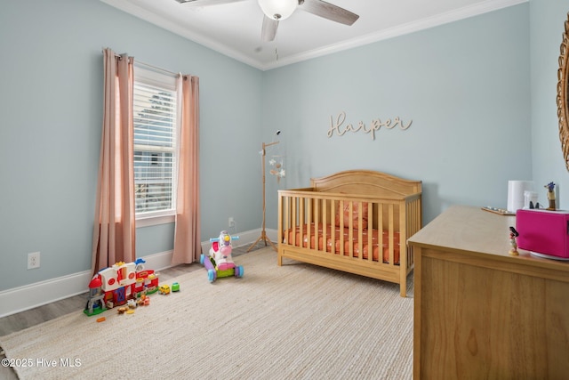 152 NW 1st St, Oak Island, NC 28465 - bedroom with ornamental molding, baseboards, a crib, and ceiling fan