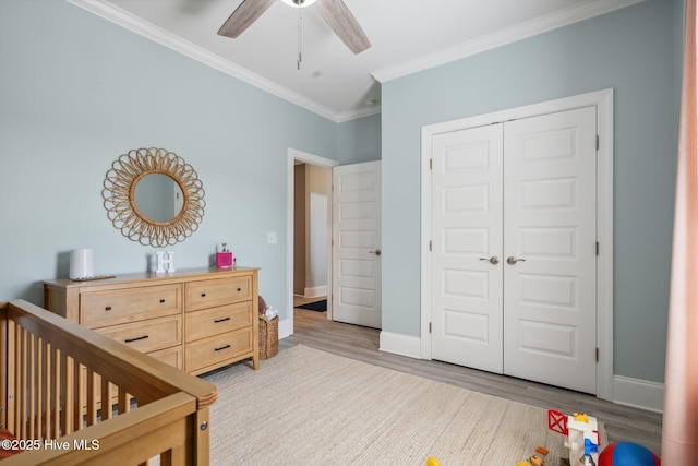 152 NW 1st St, Oak Island, NC 28465 - bedroom with ornamental molding, wood finished floors, a closet, baseboards, and a ceiling fan
