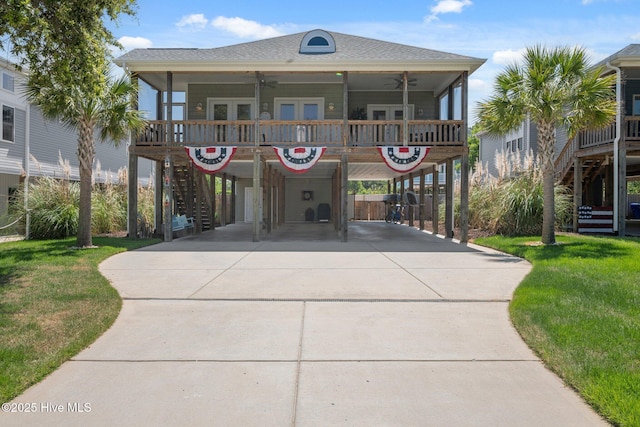 152 NW 1st St, Oak Island, NC 28465 - coastal home with stairs, ceiling fan, a carport, concrete driveway, and a front yard
