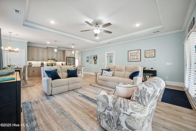 152 NW 1st St, Oak Island, NC 28465 - living area with a raised ceiling, light wood-type flooring, a ceiling fan, baseboards, and ornamental molding