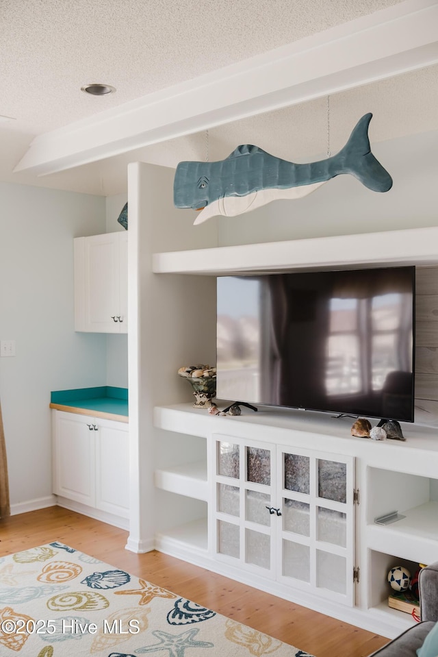 detailed view of wood finished floors and a textured ceiling