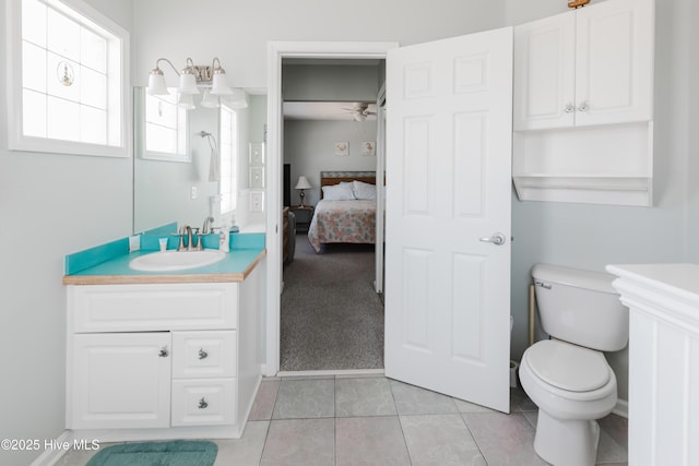 full bath with toilet, vanity, ceiling fan, tile patterned floors, and ensuite bathroom