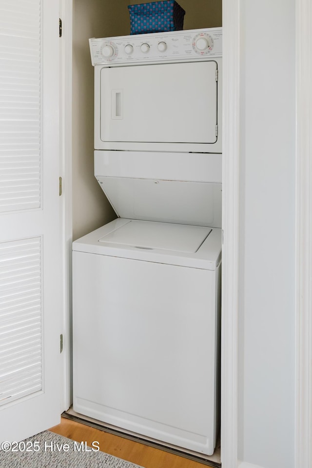 laundry room with stacked washer and clothes dryer and light wood-style floors