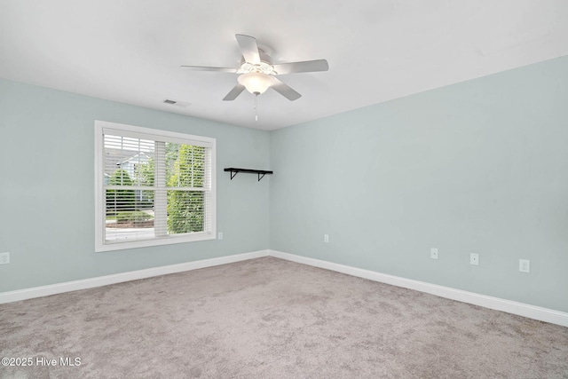 carpeted empty room with ceiling fan and baseboards