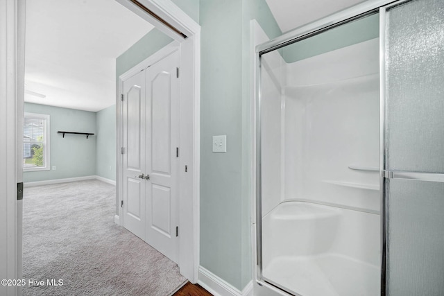 full bath with a shower stall and baseboards