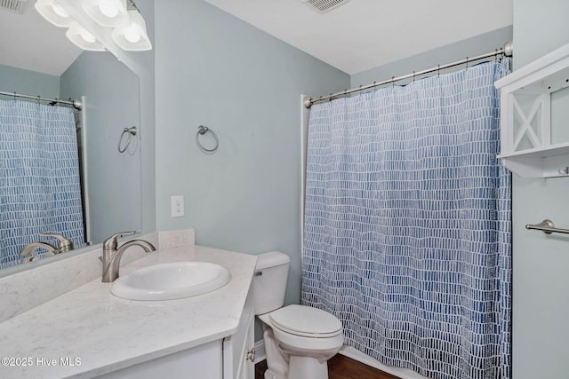 bathroom featuring vanity, toilet, and curtained shower