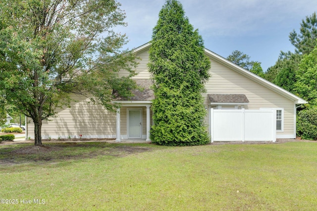view of front facade featuring a front lawn and a shingled roof