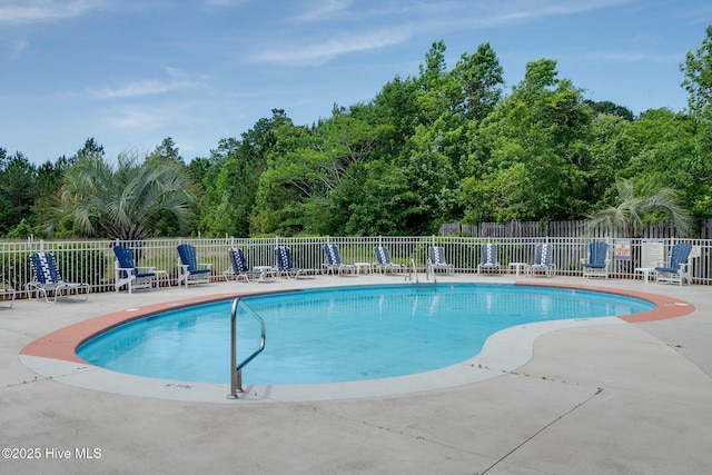 community pool featuring fence and a patio area