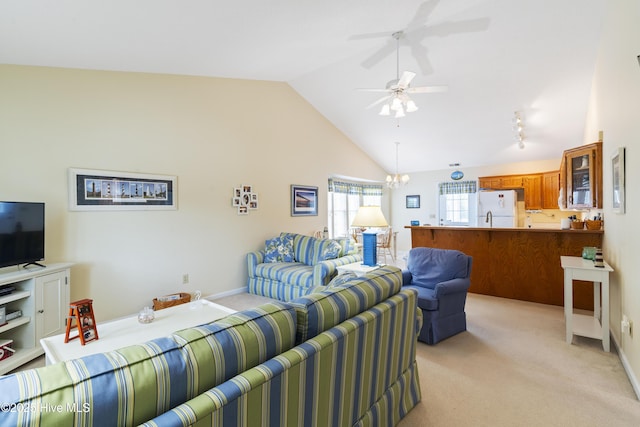 living area with light colored carpet, a chandelier, baseboards, and high vaulted ceiling