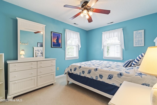 bedroom featuring multiple windows, light colored carpet, baseboards, and a ceiling fan