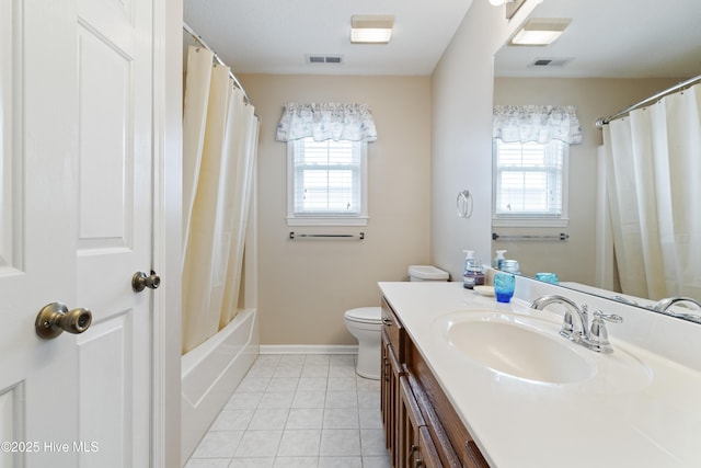 bathroom featuring healthy amount of natural light, tile patterned floors, toilet, and vanity