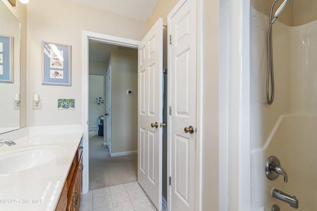 bathroom featuring vanity, tile patterned flooring, bathtub / shower combination, and baseboards