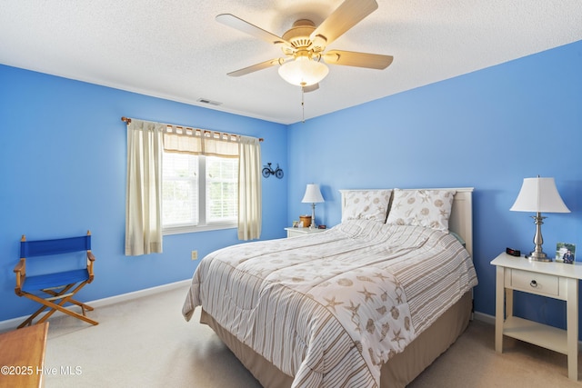 carpeted bedroom featuring baseboards, ceiling fan, and a textured ceiling