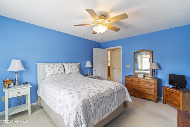 carpeted bedroom featuring baseboards and a ceiling fan