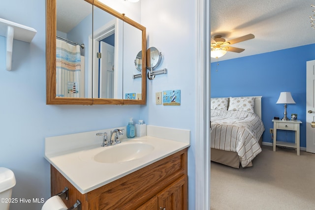 full bath featuring ensuite bath, ceiling fan, vanity, a textured ceiling, and toilet