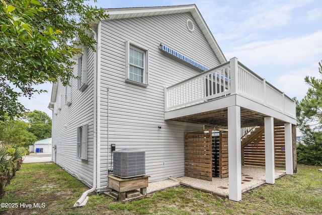 back of house featuring central AC unit, a wooden deck, and stairs