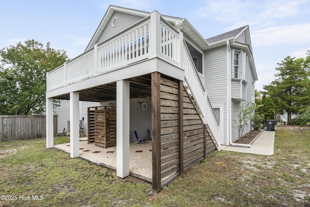 view of property exterior with a deck, fence, and stairway