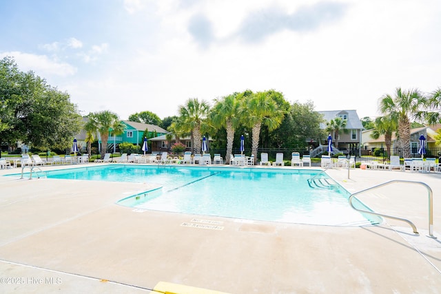 community pool featuring fence and a patio area