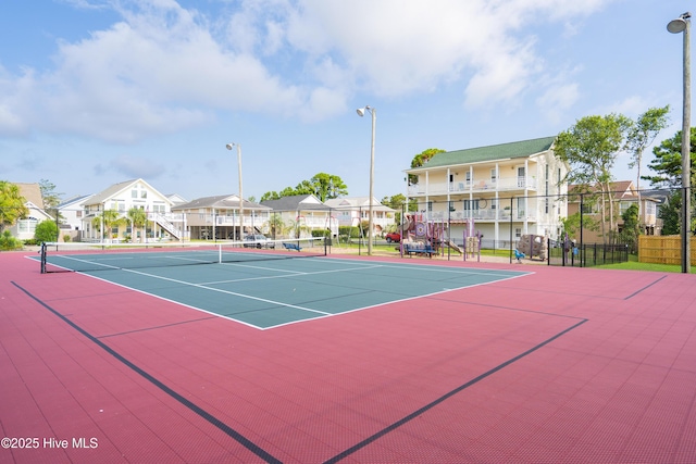 view of tennis court featuring fence, a residential view, and community basketball court