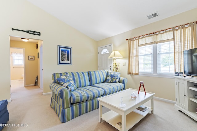 living area featuring carpet flooring, baseboards, and lofted ceiling