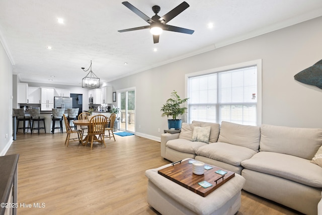 living room with ornamental molding, baseboards, recessed lighting, a ceiling fan, and light wood-style floors