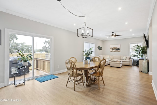 dining space with baseboards, light wood finished floors, recessed lighting, ornamental molding, and a chandelier
