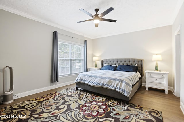 bedroom with ornamental molding, wood finished floors, baseboards, and a ceiling fan