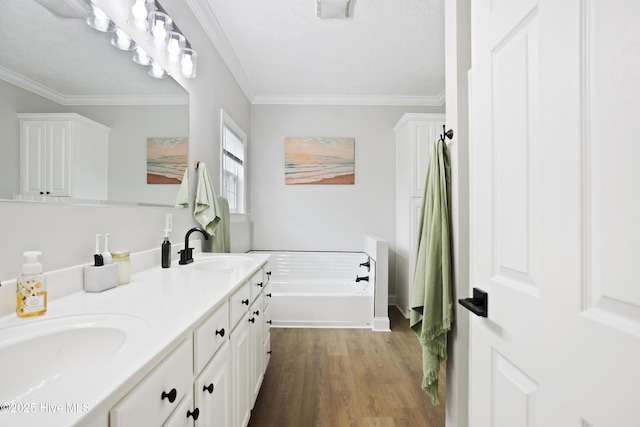 bathroom with a garden tub, wood finished floors, double vanity, and ornamental molding