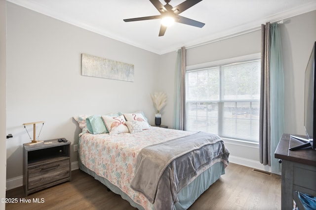 bedroom with ornamental molding, multiple windows, wood finished floors, and baseboards