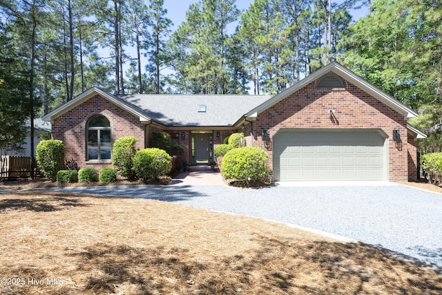 ranch-style house with driveway, brick siding, a garage, a shingled roof, and fence