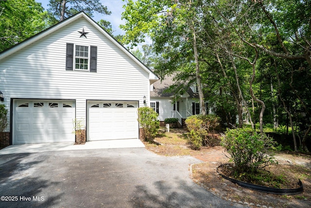 view of front of home featuring driveway, a garage, and brick siding