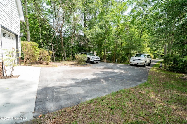 view of yard with asphalt driveway