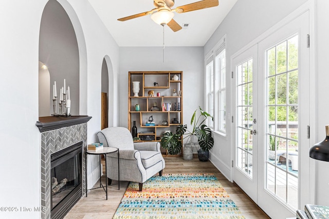 sitting room featuring healthy amount of natural light, wood finished floors, and a ceiling fan