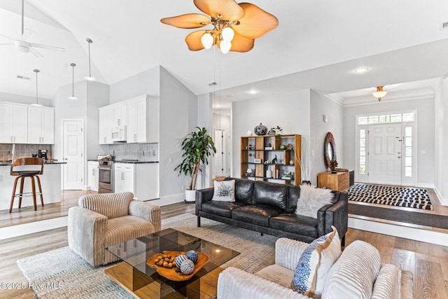 living area featuring ceiling fan, light wood-style floors, baseboards, recessed lighting, and crown molding