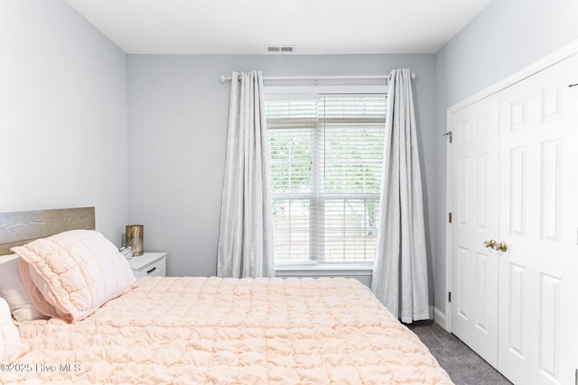 bedroom with dark colored carpet and a closet
