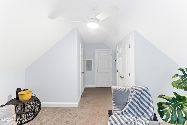 living area with carpet flooring, baseboards, vaulted ceiling, and a ceiling fan