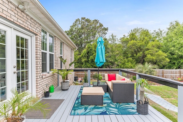 wooden terrace with outdoor lounge area and fence