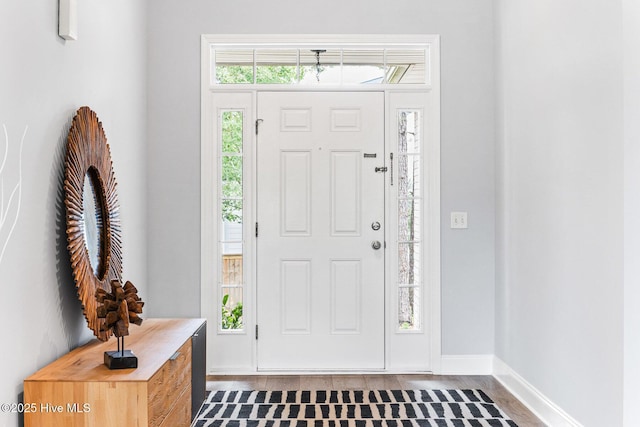 entrance foyer with dark wood-style floors and baseboards
