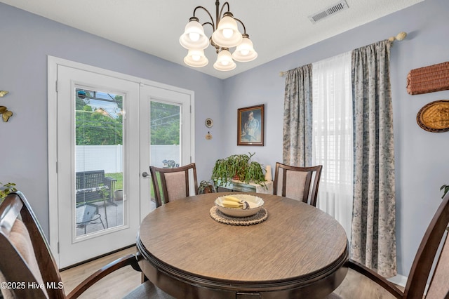dining room featuring wood finished floors, a chandelier, and baseboards