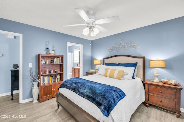 bedroom with light wood-style flooring, baseboards, ceiling fan, and ensuite bath