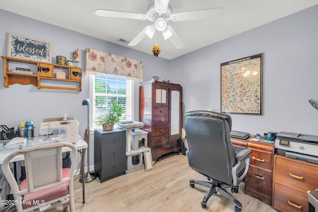 office area with light wood finished floors and ceiling fan