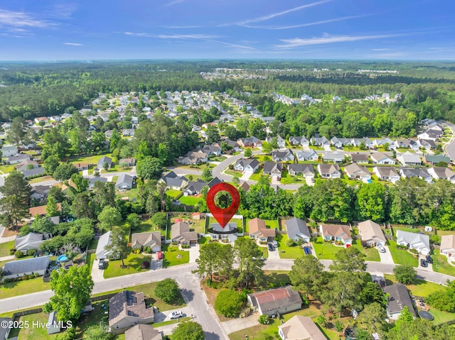 aerial overview of property's location featuring nearby suburban area and a heavily wooded area