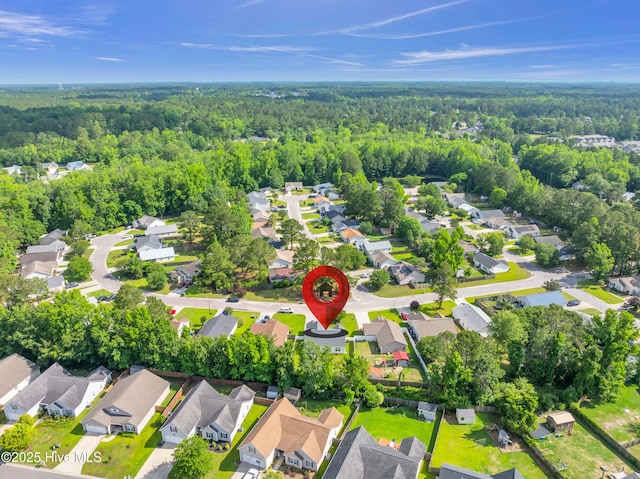 view of property location featuring a forest and nearby suburban area