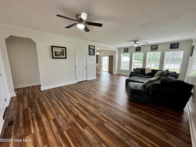 146 N Ravenwood Ln, Belhaven, NC 27810 - living room featuring arched walkways, ceiling fan, dark wood-type flooring, crown molding, and baseboards